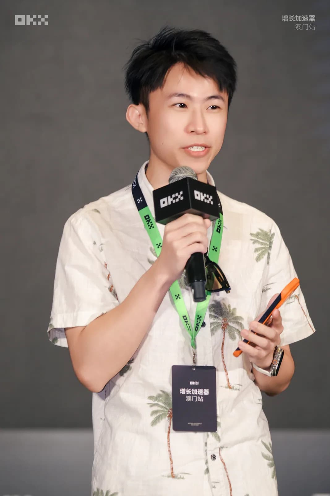 氣球柯男在 OKX 增長加速器澳門站手持麥克風分享,掛澳門站識別證